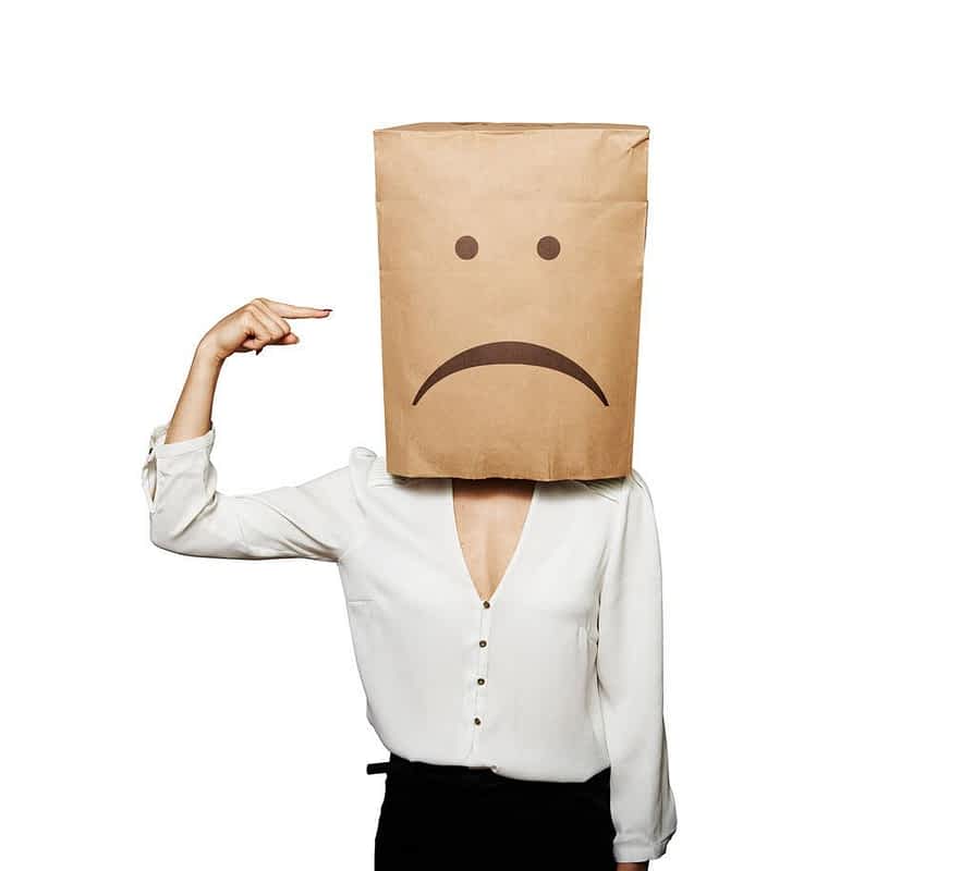 depressed woman pointing at paper bag