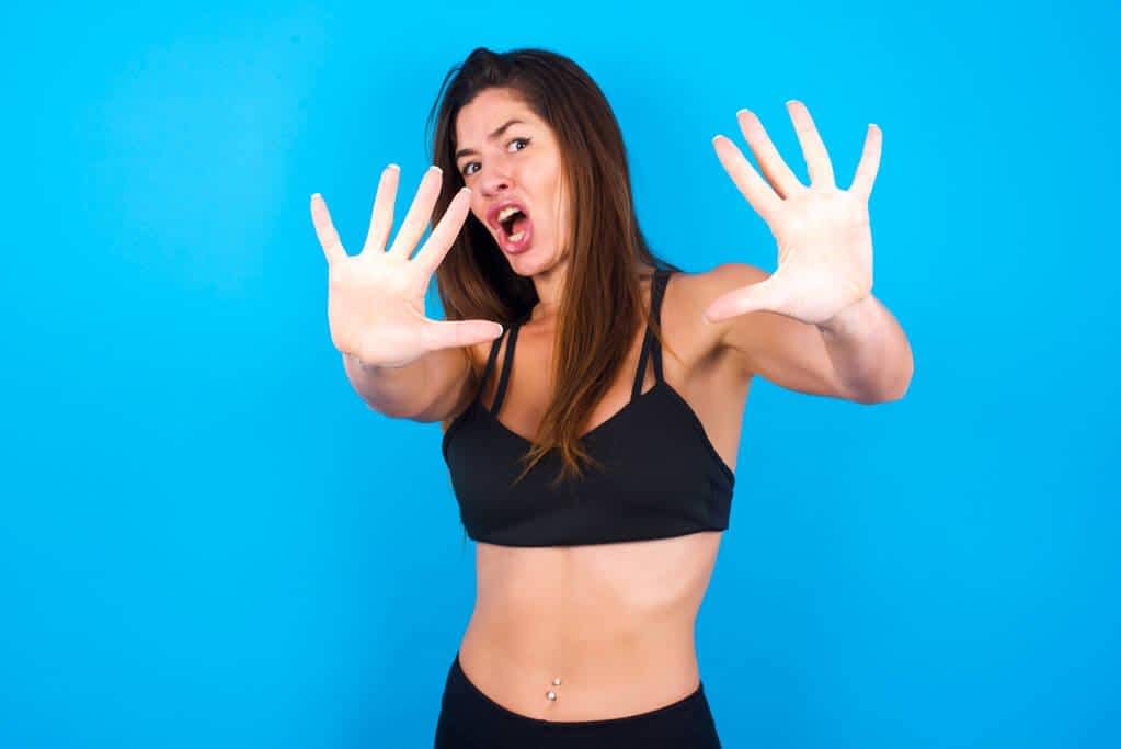 3 Secret Clues Your Body Is Rejecting Someone 8 brunette woman wearing sportswear frowns disgusting The Ick