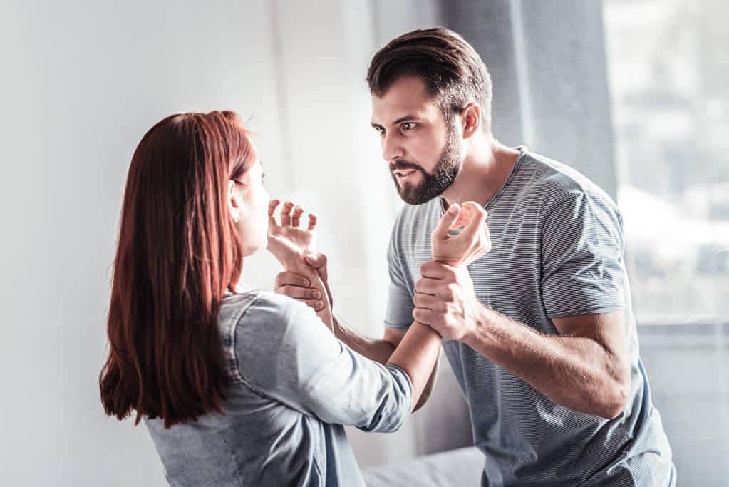 angry emotional man holding his wifes hands
