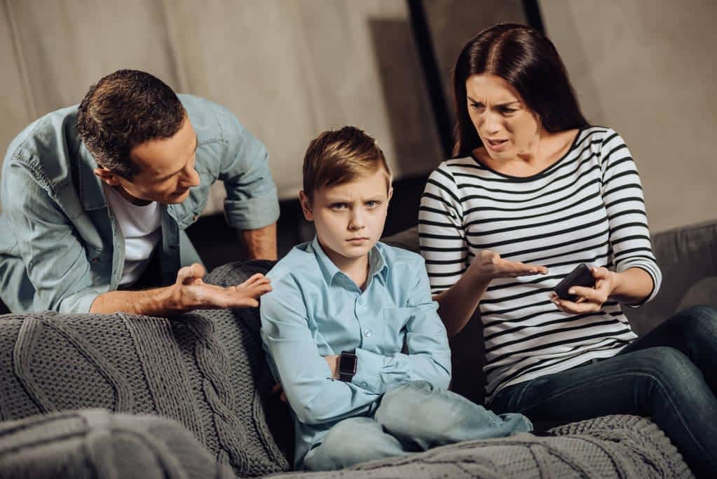 young parents explaining son about drawbacks of binge playing