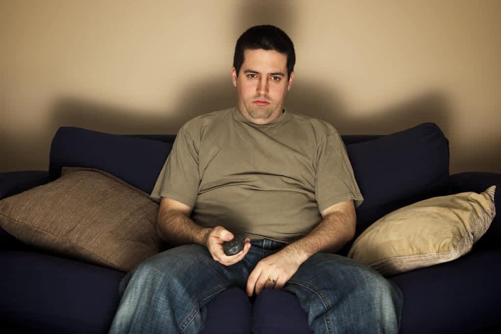12 Alarming Signs He’s Disrespecting You Without You Knowing 7 bored overweight man sits on the sofa
