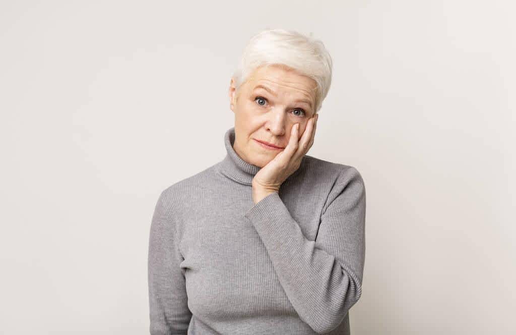 7 Emotional Pitfalls You Need to Avoid During Gray Divorce 6 shocked senior woman holding cheek up in total disbelief