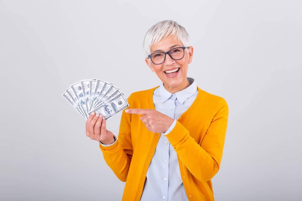 happy senior woman holding lots cash