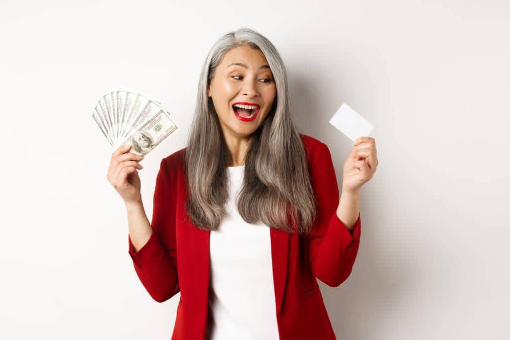senior woman earn money showing dollars in cash