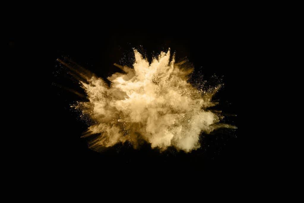 golden powder explosion black background colored cloud colorful dust