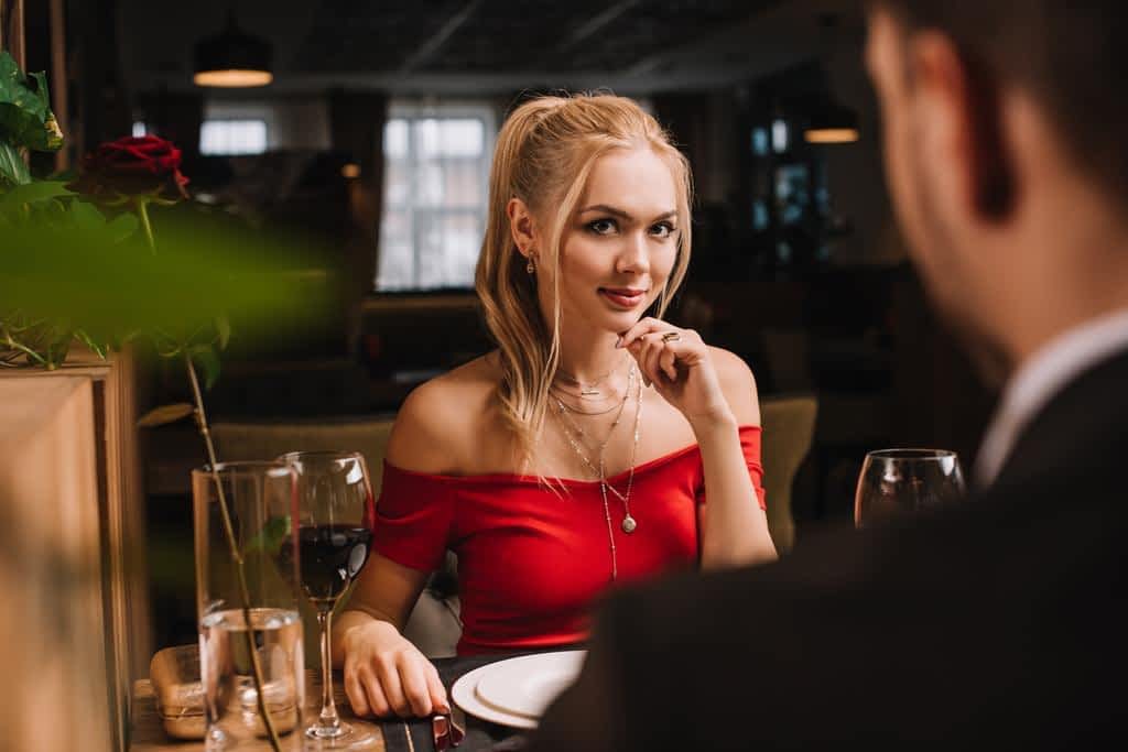 selective focus attractive woman flirting man restaurant