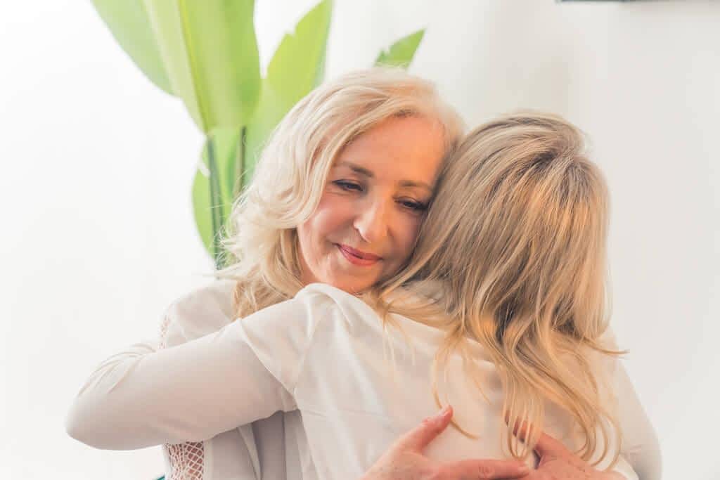 The 11 Unexpected Silver Linings of a Gray Divorce 11 woman straight blonde hair hugging middle aged