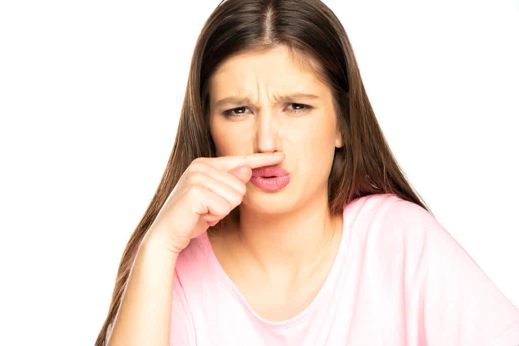 young woman bad smell gesture white bacground