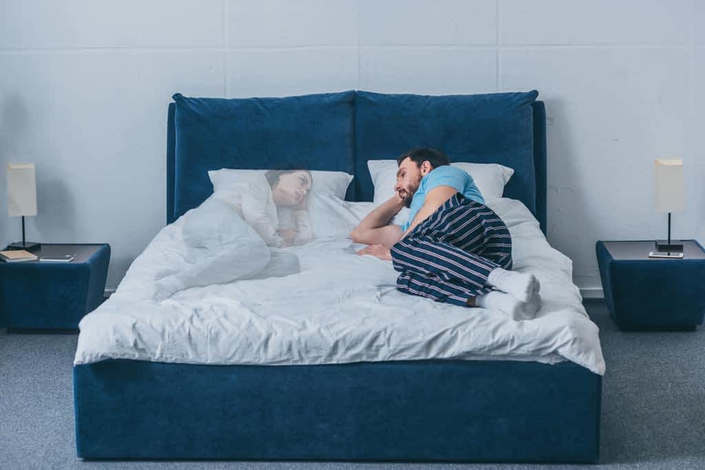 11 Types of Men Who Get Dumped: Brutal Reasons Women Leave 3 depressed man lying bed looking wife ghost