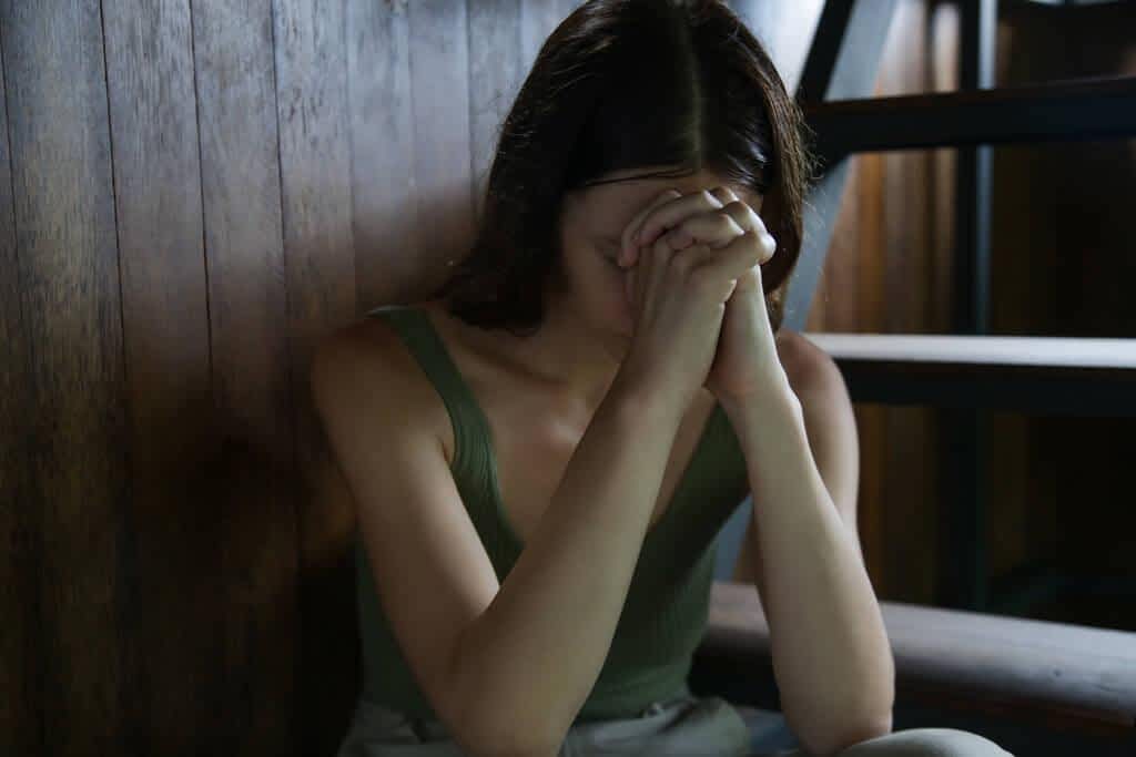 portrait depressed woman covering face her hands