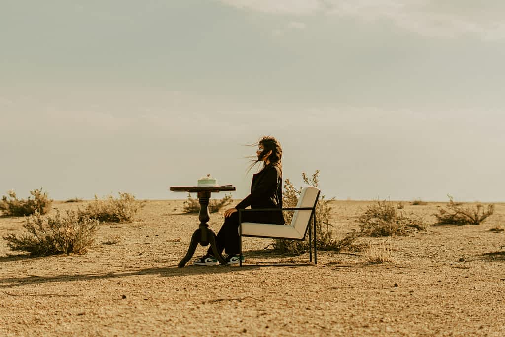 When Strong Women Break: The Painful Cost of Never Asking for Help 2 woman sits on a chair alone in the desert