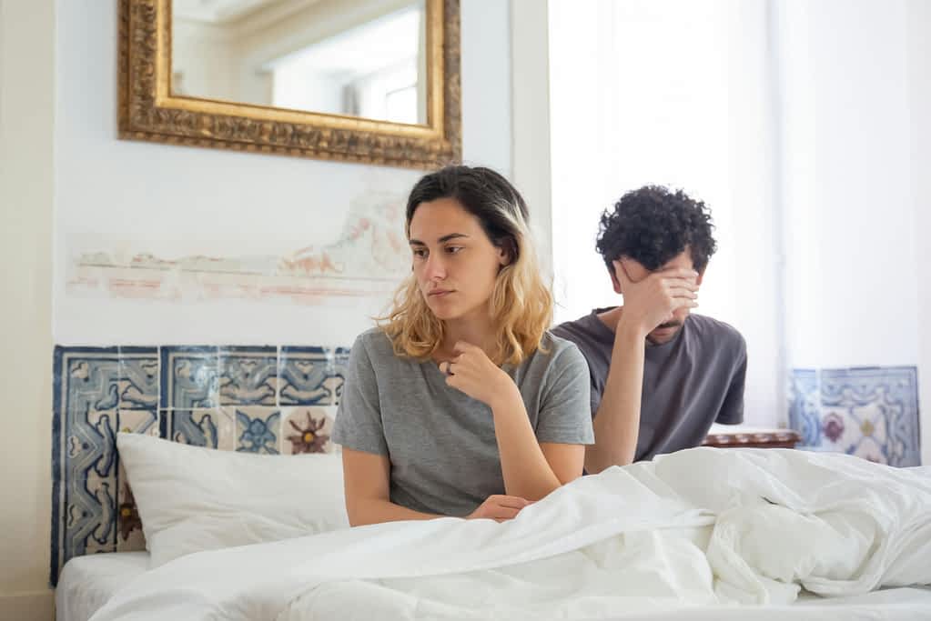 Touch Starvation: The Relationship Problem We Don't Talk About 2 unhappy couple in bed
