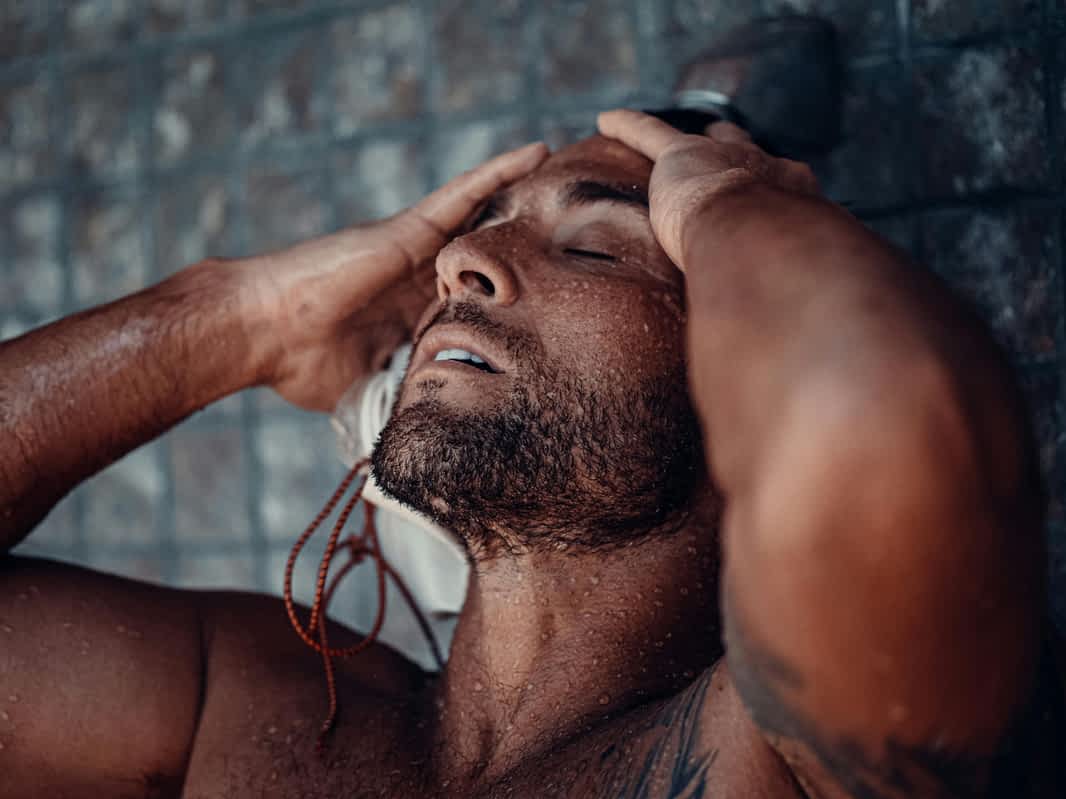 man practicing good hygiene taking a shower and getting clean