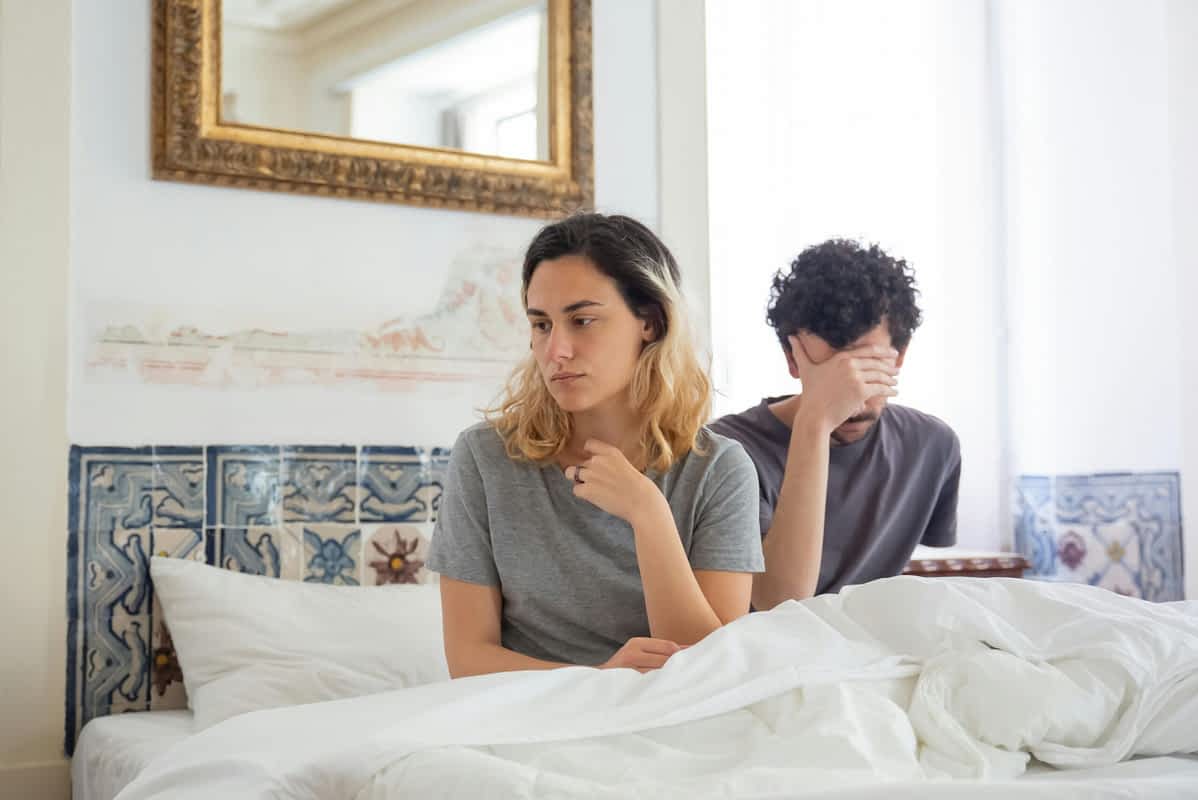 unhappy couple in bed