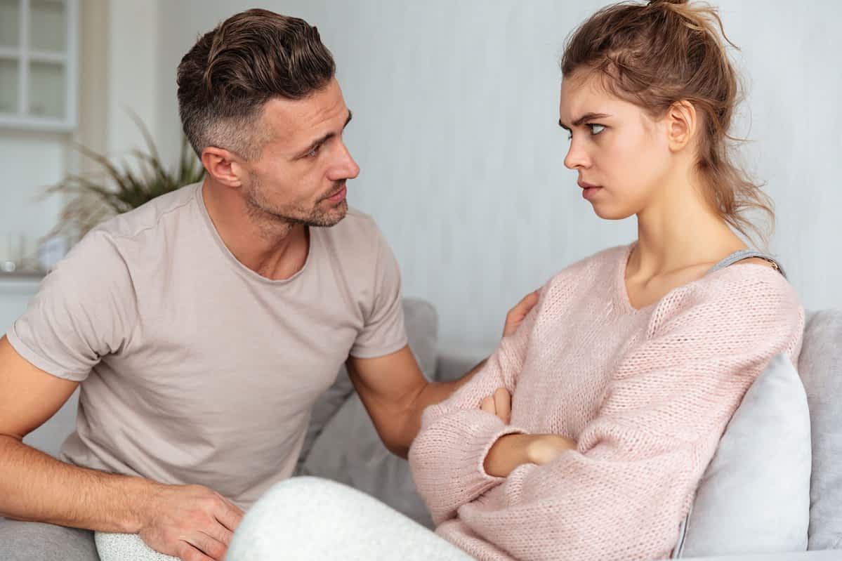 woman glares at man trying to talk to her over their relationship difficulties