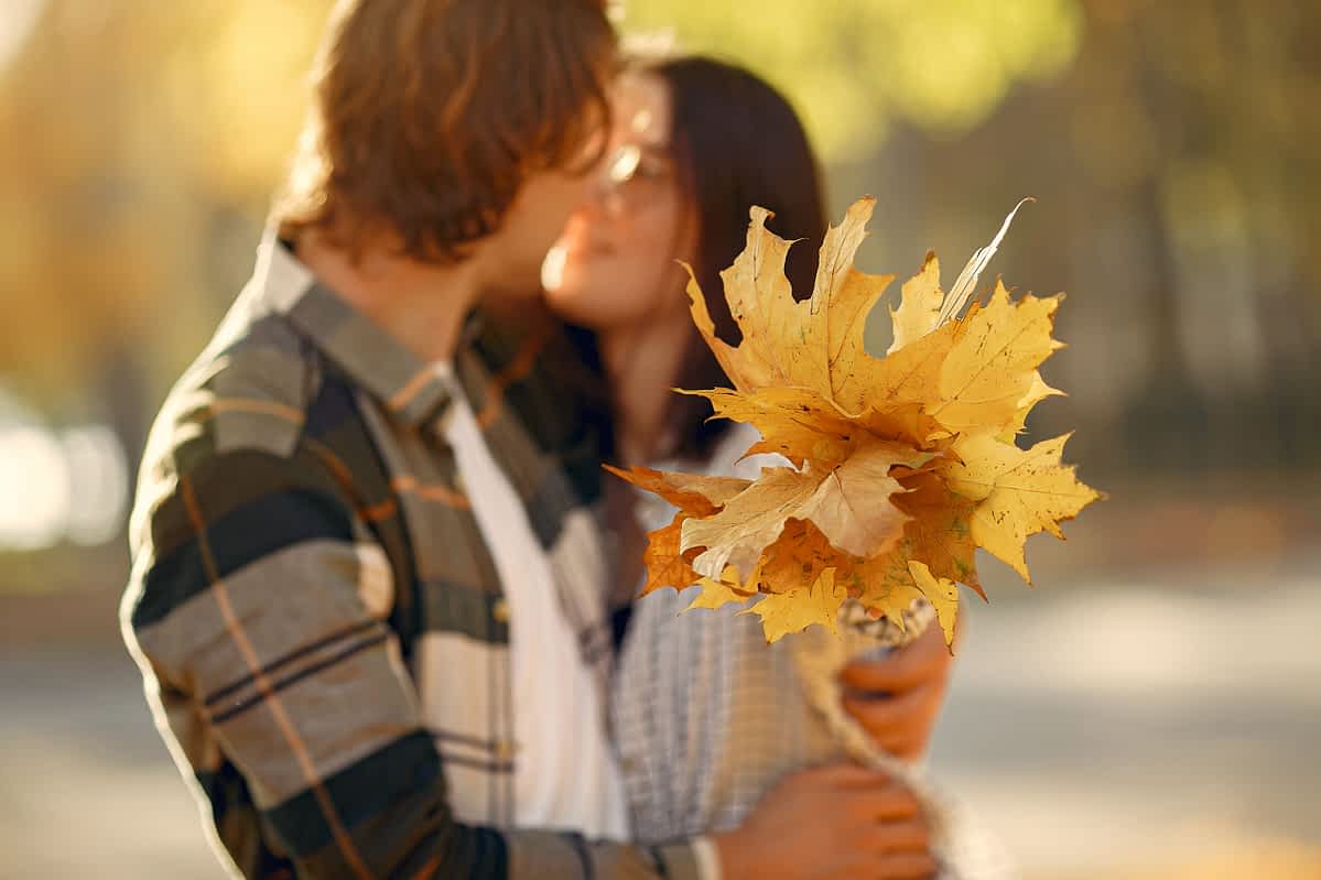 Couple in a park. Guy in a white t-shirt. Golden autumn