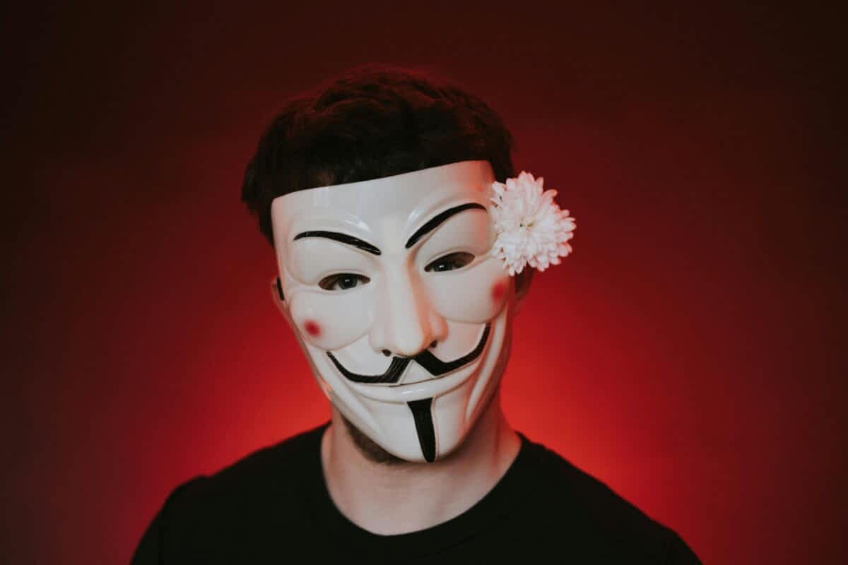 creepy man wearing a mask and a flower tucked behind his ear