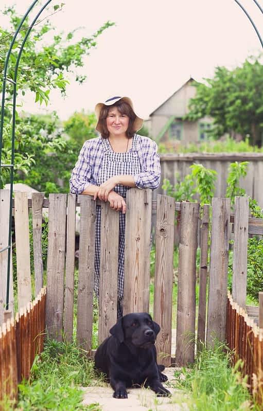 happy woman in the garden with her labrador dog
