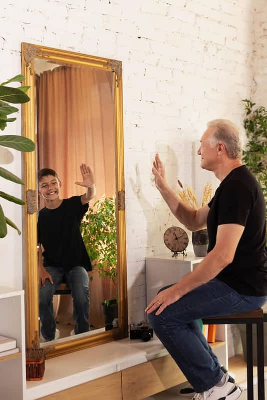 9 Absurd Reasons Why Happily Single Women Trigger Men 4 senior man his younger self reflected mirror both smiling