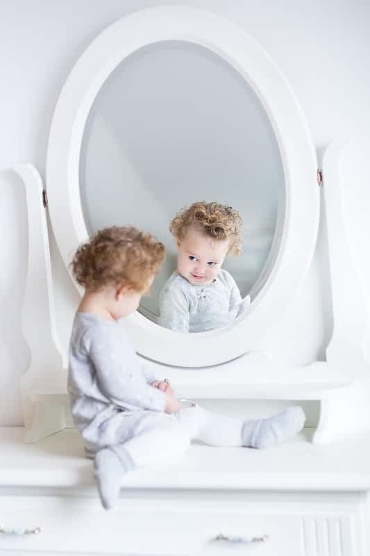 Helicopter Parenting and Narcissism: The Hidden Connection 9 baby girl watching her reflection in a mirror