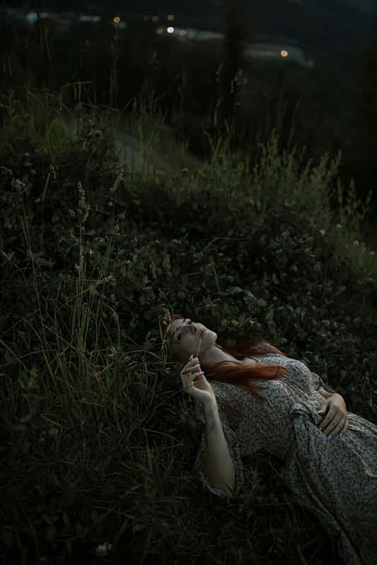 woman lying in the grass in the dark