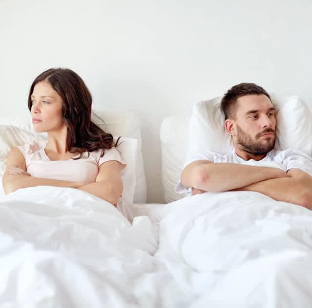 unhappy couple in bed