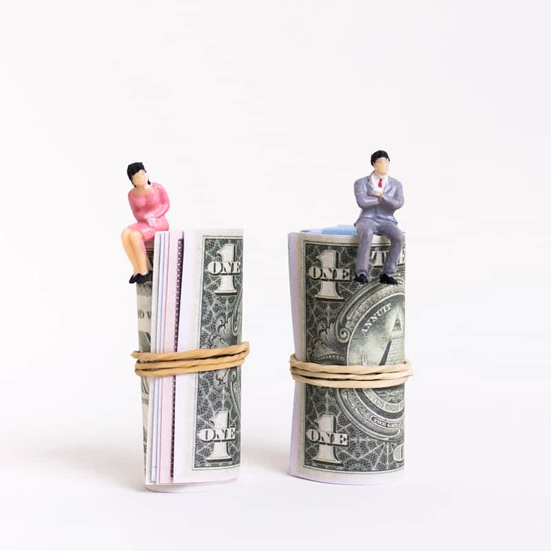 man and woman sitting on top of rolls of money