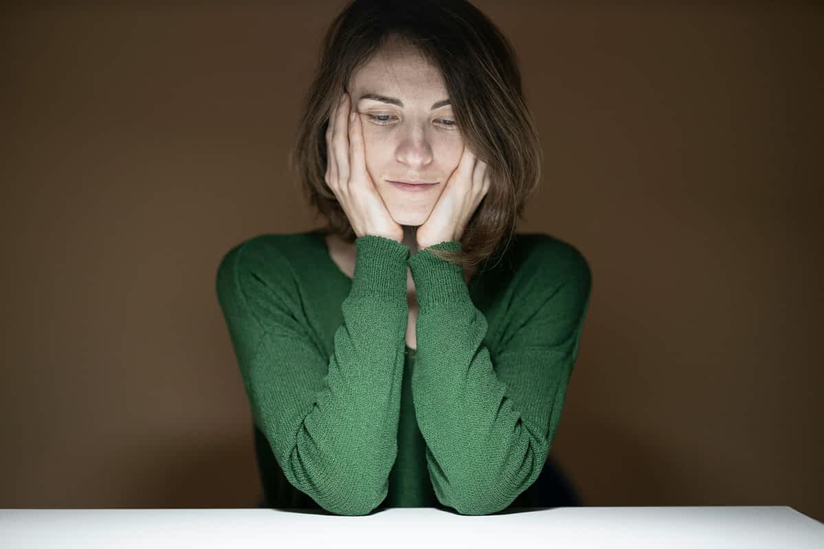 The One Lie That Kept Me Stuck for 30 Years 7 somber woman with her hands on her face