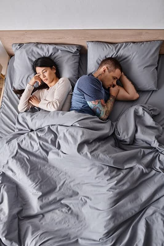 Projecting Insecurities in Relationships: 9 Toxic Ways It Wreaks Havoc 14 high angle view depressed interracial couple lying bed home family