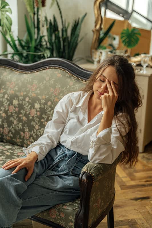 The One Lie That Kept Me Stuck for 30 Years 2 tired, depressed woman sits on a couch